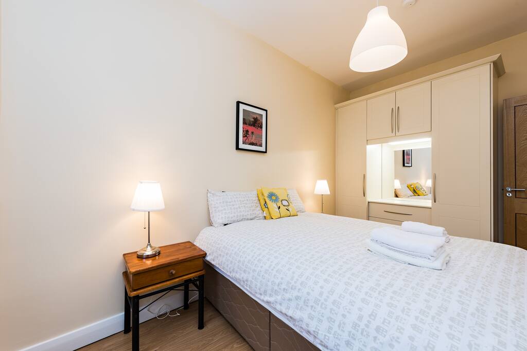 Bedroom with double bed, wardrobe, wooden floor