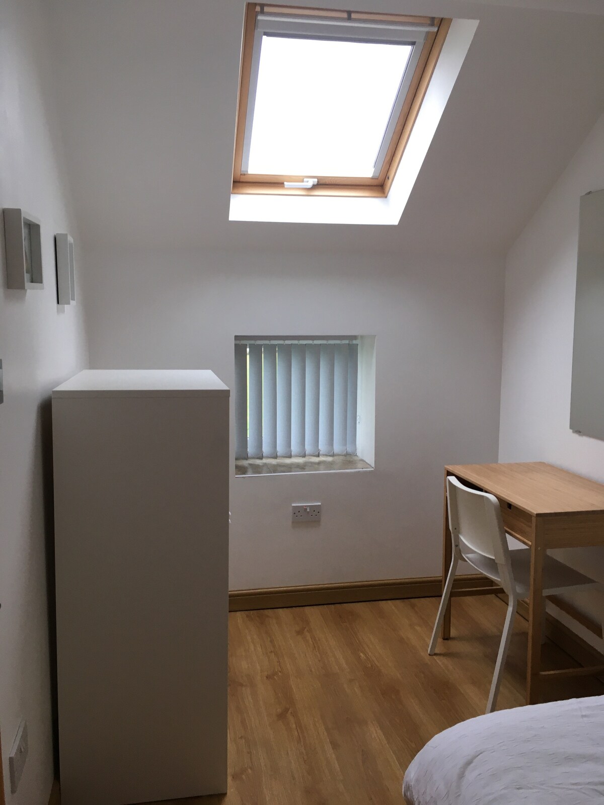 ห้องนอนเดี่ยวพร้อมโต๊ะทำงานตู้เสื้อผ้าเปิดโล่งพร้อมชั้นวางของและพื้นที่แขวน