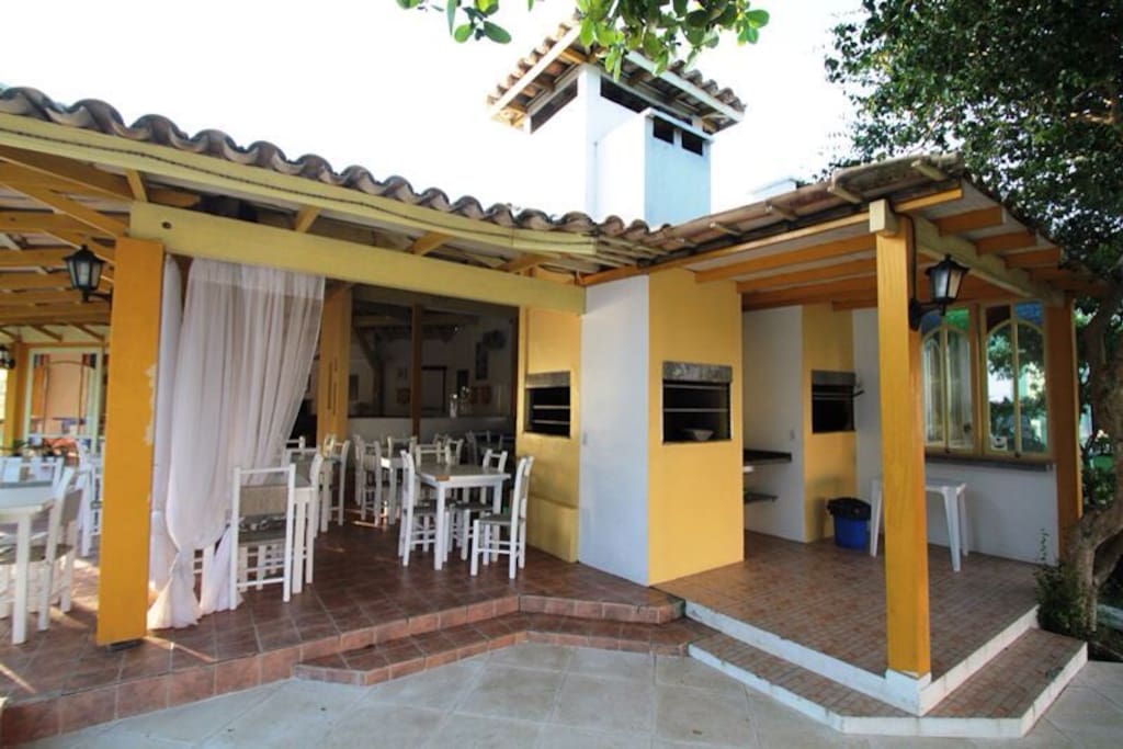 Infraestrutura condominial com churrasqueiras externas ao lado da piscina
