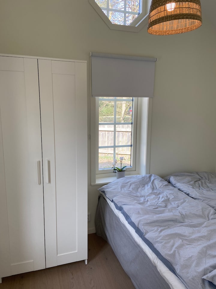 Spavaća soba u prizemlju s krevetom veličine 2x80 cm i ormarom.