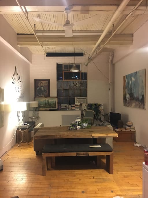 Open kitchen living space with large harvest table and three seater couch