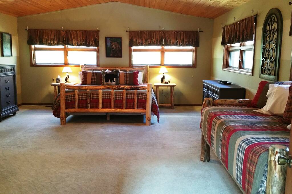 Bedroom #1 featuring a rustic log king sized bed, and a rustic log twin sized bed.