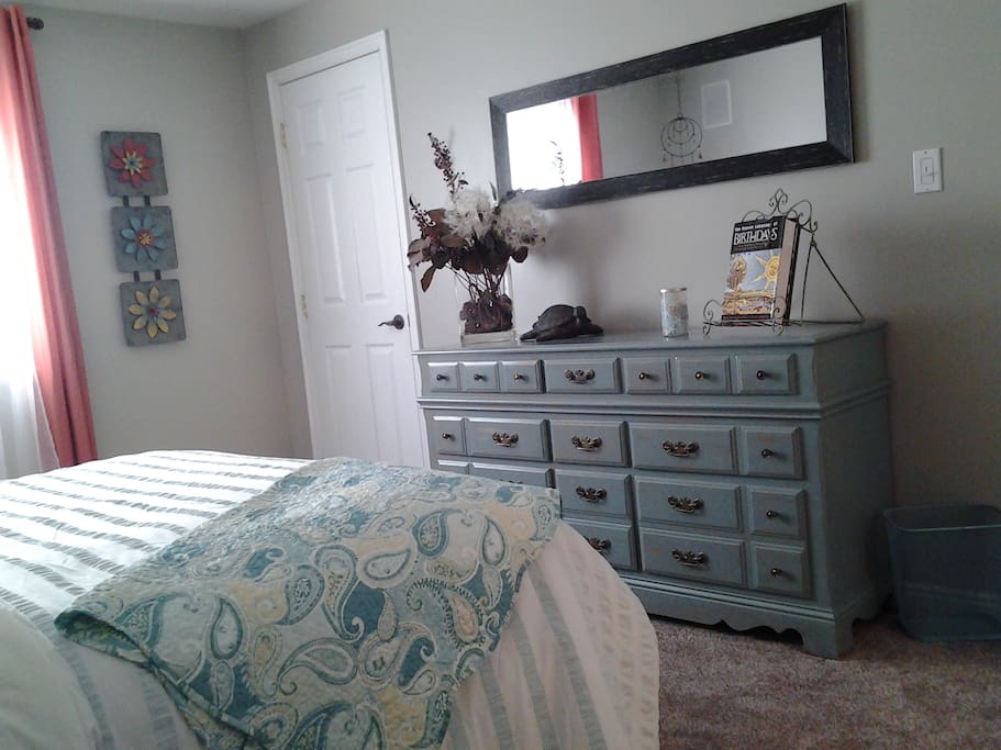 Bedroom w/queen size bed and dresser with walk in closet.