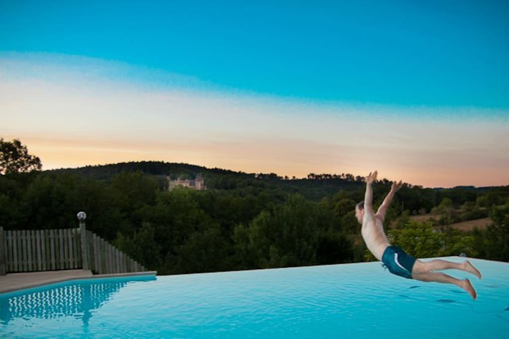 Piscine chauffée à débordement avec vue panoramique sur le château de Puymartin