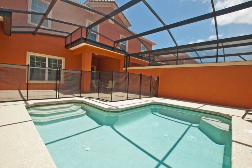 Beautiful screened-in pool area with pool furniture and loungers