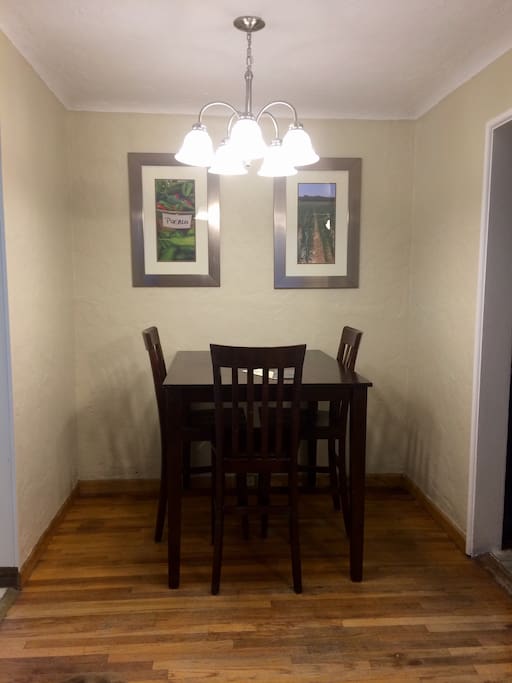 A tall but small dining table is towards the back of living room and just off the kitchen. We got quite a deal on the table and chairs because they're pretty scratched up, but will be beautiful some day. We only have three chairs for the table and they too need to be refinished too.