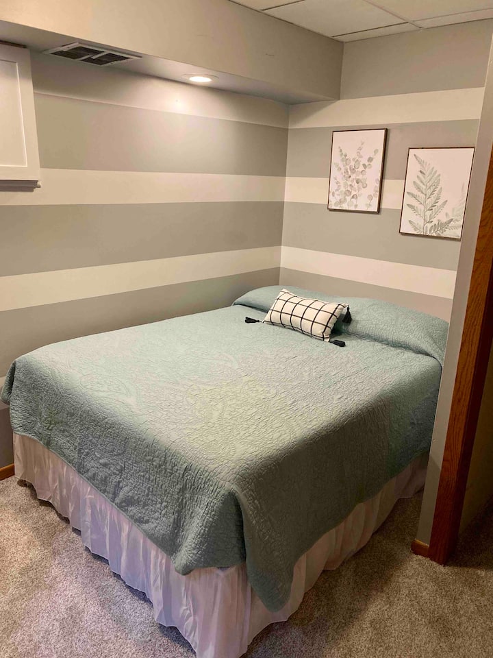 Una cama tamaño queen en el único dormitorio del sótano.