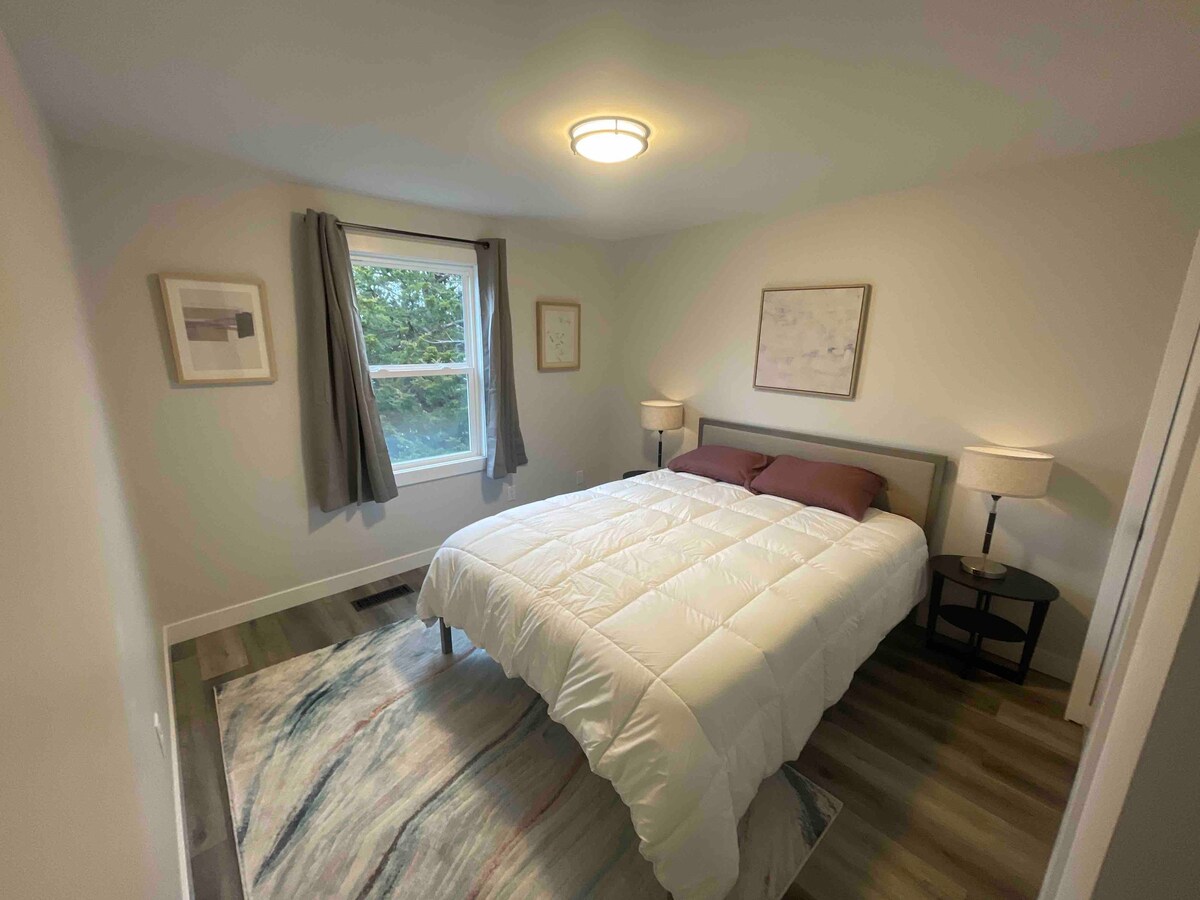 Slaapkamer #1 met comfortabele, nieuwe, queensize slaapkamer en grote kast.  Bureaulampen zijn voorzien van stopcontacten voor het opladen.
