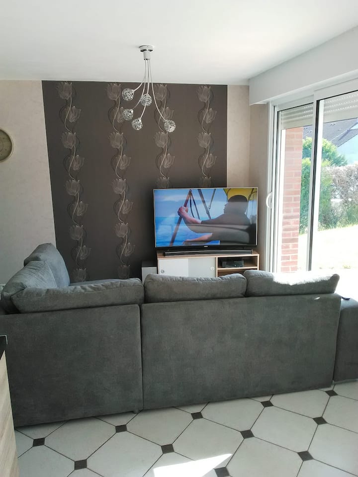 Sehemu ya kupumzika ya sofa, dirisha la ghuba na mwonekano wa bustani iliyofungwa.