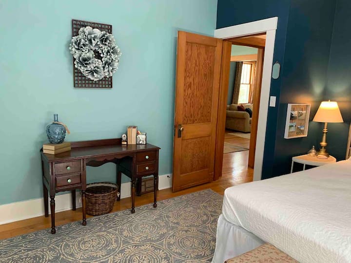 De achterslaapkamer heeft niet alleen een queensize bed geflankeerd door twee nachtkastjes met lampen, maar beschikt ook over een antiek bureau voor het werken op afstand of om als wastafel te gebruiken. 