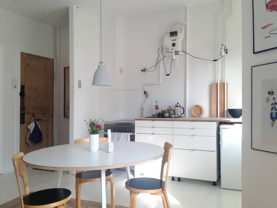 The kitchen and dining table seen from the balcony door. On the left is the entrance door.