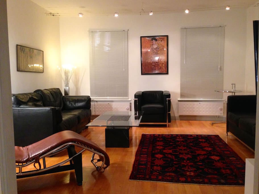 Living room with leather settees and marble/glass tables. Persian rug