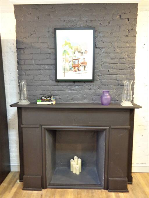 Decorative fireplace adds charm to this spacious bedroom.