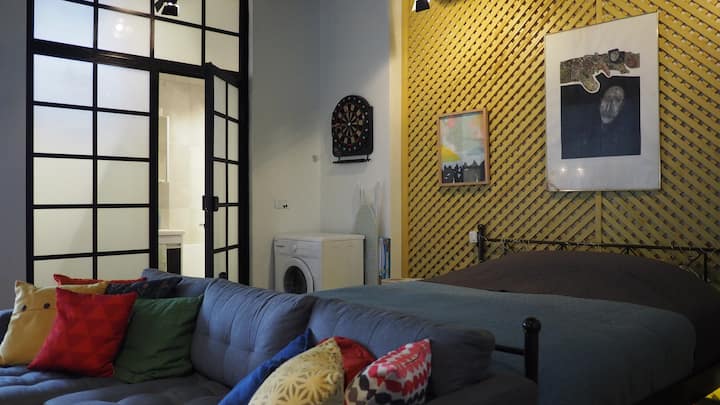 Dnevni boravak okrenut prema vratima kupaonice i zidu kreveta.