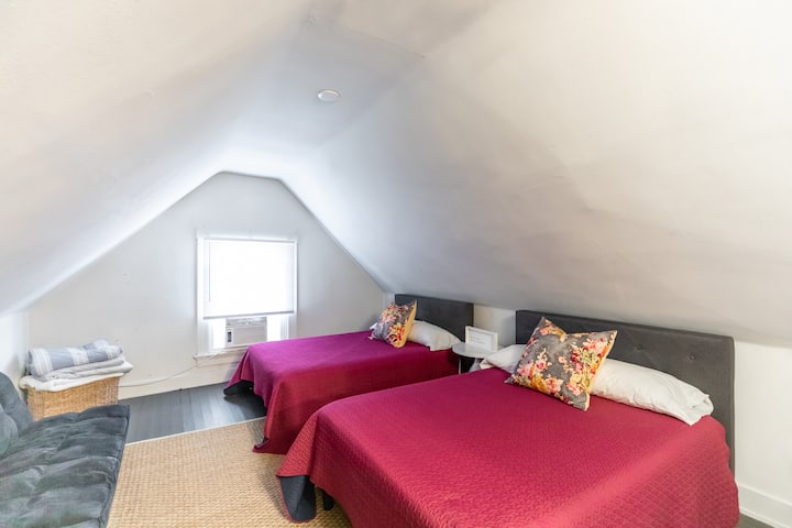 Dormitorio en el tercer piso con dos camas dobles y un futón. 