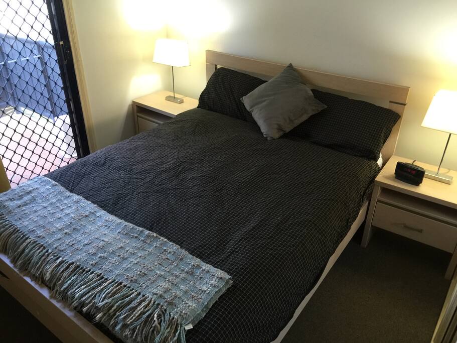 Main Bedroom: Queen bed all bedding supplied. Sheets, pillow cases, doona, bedside tables and bedside lights, fan, built-in mirrored wardrobe. Block out curtains. Security door, access to balcony