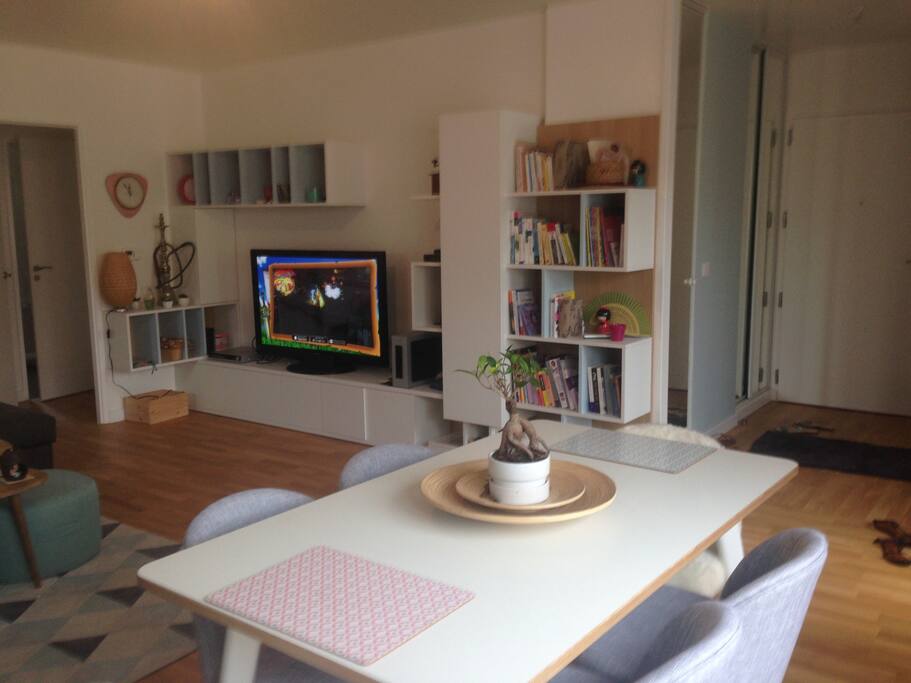 grand salon chaleureux avec une grande table pour les repas et une télé à disposition