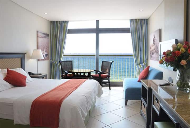 Dhomë gjumi kryesore me pamje nga deti dhe pishina me rrëshqitës që hapen në një ballkon të tipit Frwnch 