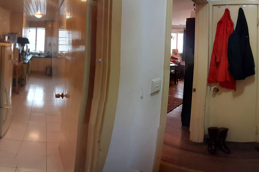 "Surround" view of long & skinny kitchen, entryway area looking into living room.