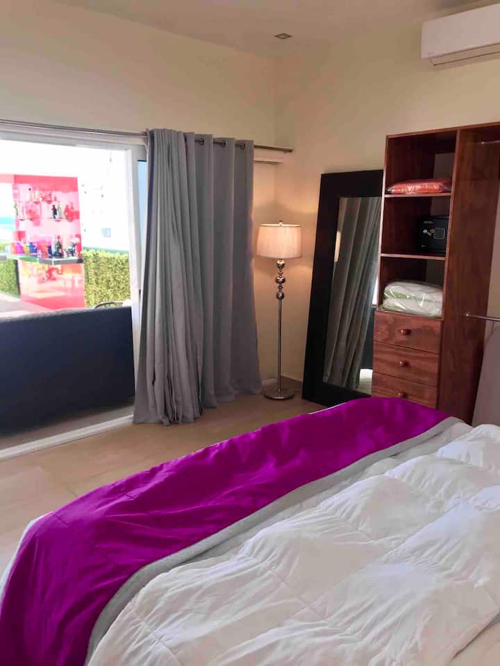 Habitación principal con cama King y vista completa del penthouse despierta con la brisa y luz del sol caribe