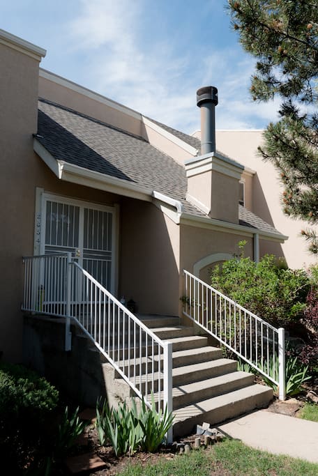 The front door opens onto a grassy area with lots of beautiful trees.