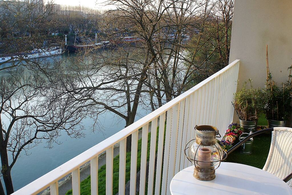 Coin repas avec la vue sur les péniches, les arbres, les canards et les cygnes