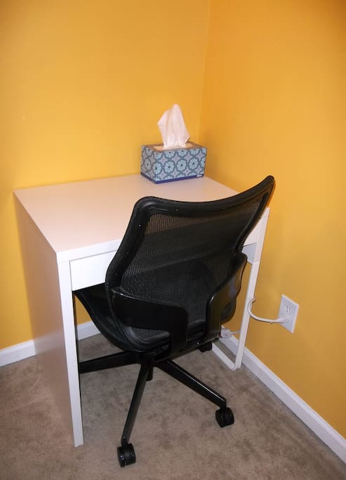 A small desk with a power strip