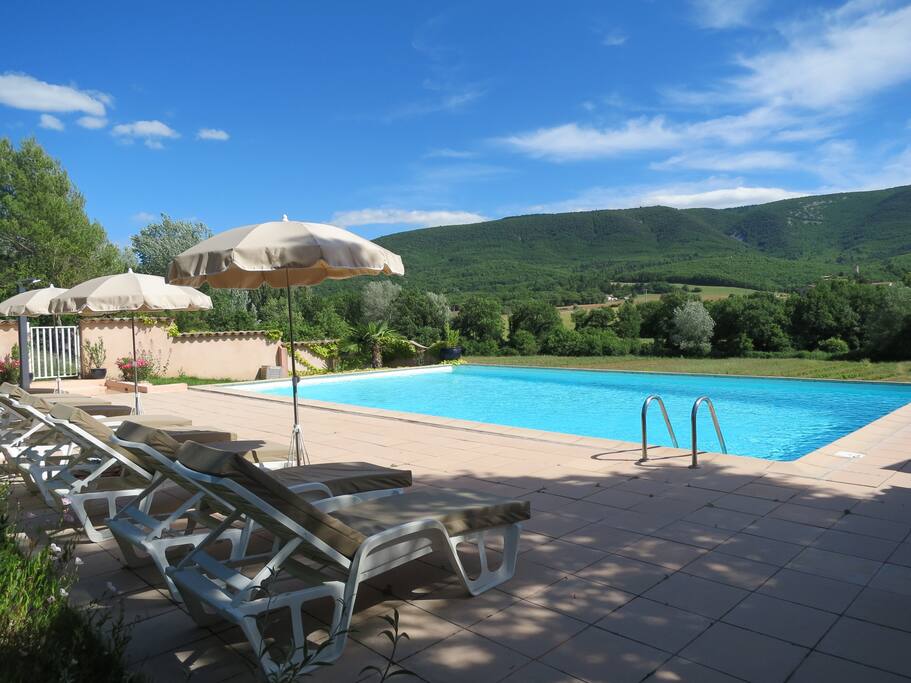 Piscine avec vue sur le Luberon, grande plage équipée de bains de soleil et parasols, douche extérieure et salle de bain