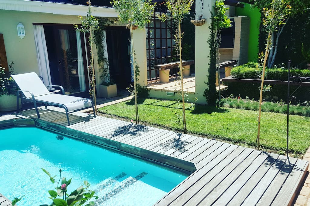 Pool deck with loungers surrounded by the tranquil and secluded garden.