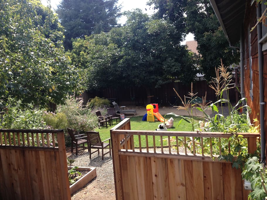 Large fully fenced yard has plenty of kid items including a sandbox, playhouse, strollers and more.
