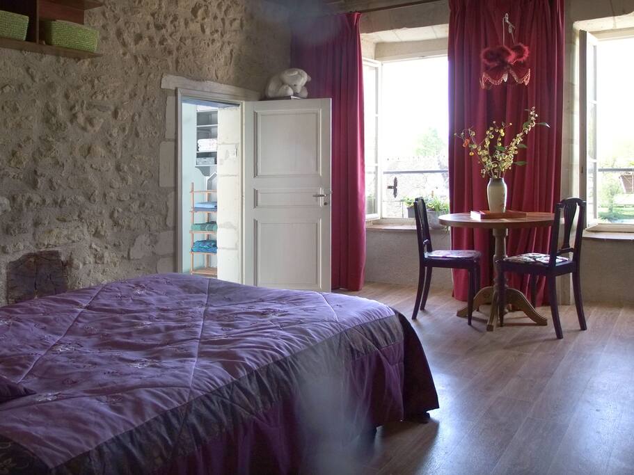 La chambre double : le lit, la table et la porte de la salle de bain