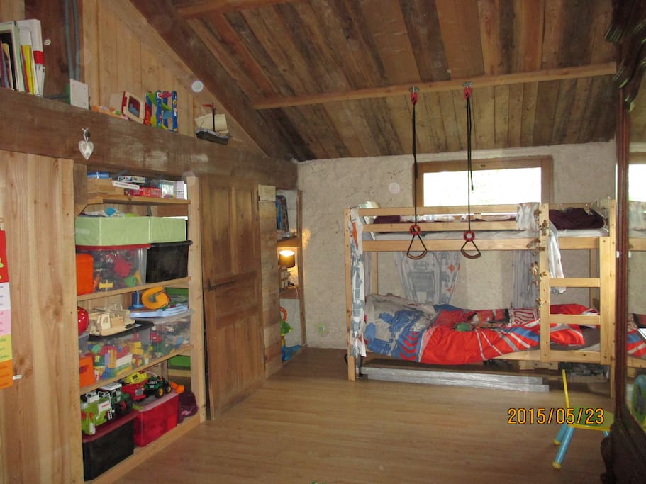 grande chambre avec un lit superposé et un lit à barreau