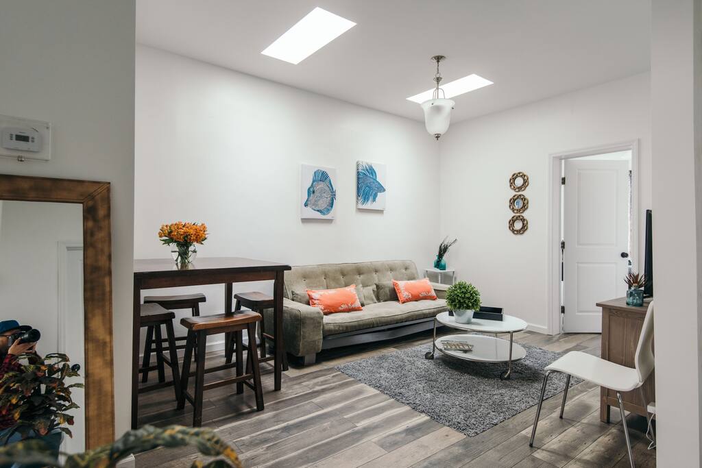 A large spacious living room with flat screen tv, large futon and a dining table with stools for you and your guest to sit around, enjoy breakfast and plan and discuss your day ahead. Lots of natural light beaming down from newly installed sky lights.