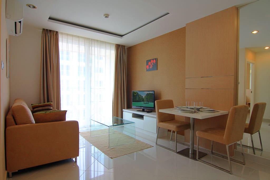 Cozy apartment with sofa and TV in living room, dining and kitchen, balcony