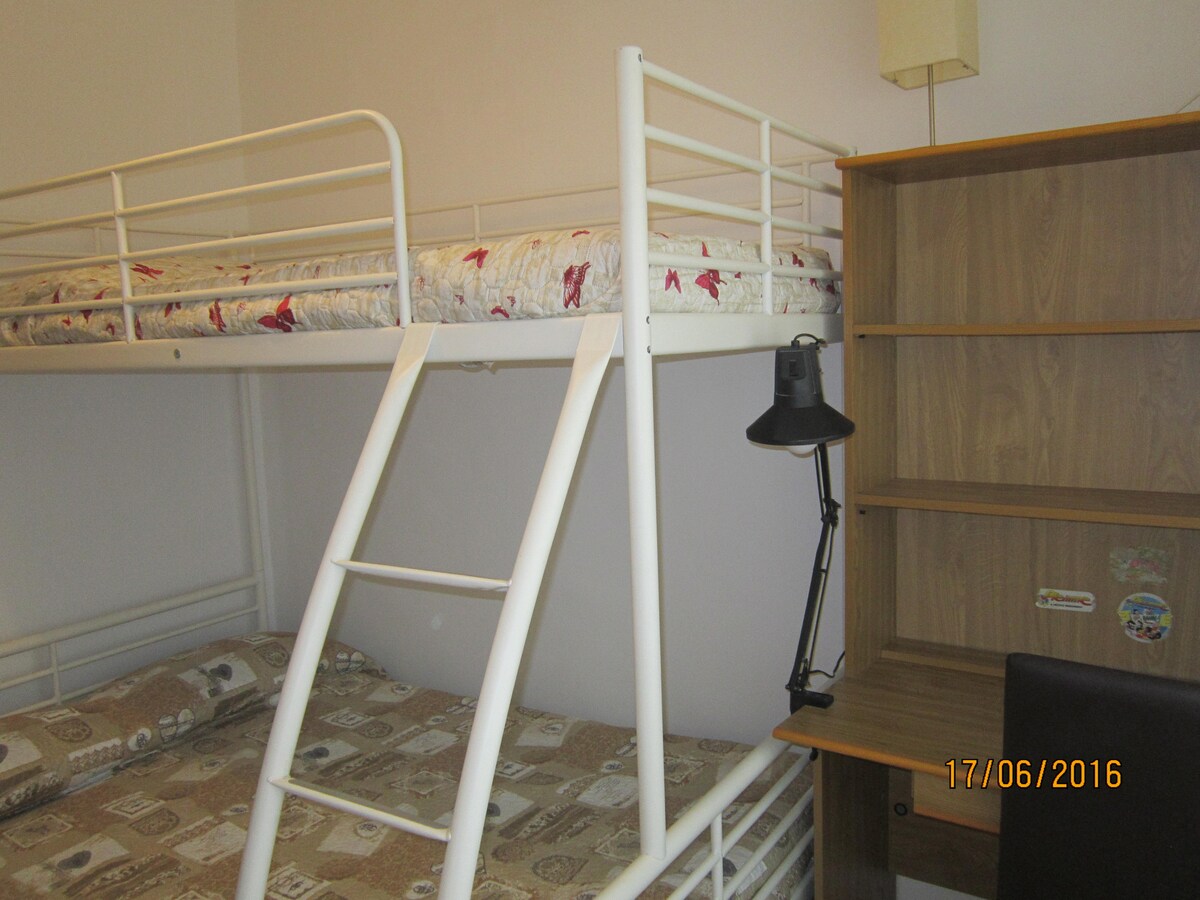 חדר עם מיטת קומותיים מעל מיטת יחיד ומתחת לכיכר וחצי