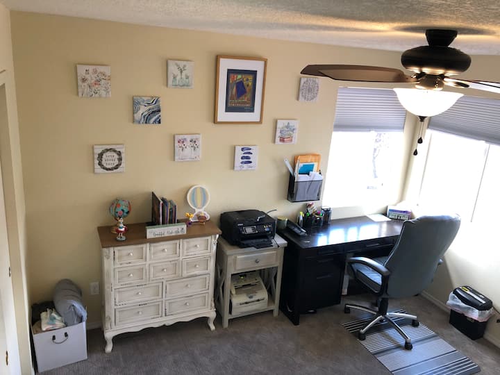 Kantoor in slaapkamer 2, met wifi-printer en kantoorbenodigdheden. Op het dressoir liggen meerdere kinderboeken.