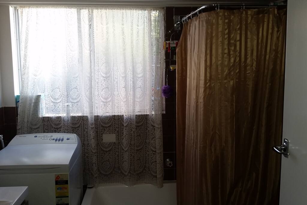 Large bathroom with full size tub, shower and washing machine. Dryer located on the back patio.