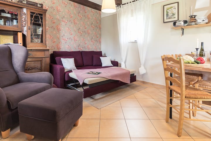 Gemütliches Sofa im Erdgeschoss, das sich mit wenigen Handgriffen in ein komfortables Schlafsofa (1,60 x 2 m) für zwei Personen verwandeln lässt – ideal für zusätzliche Gäste oder entspannte Abende.