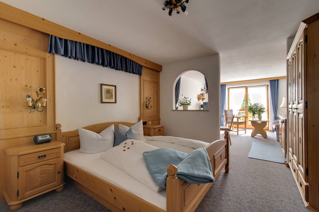 Schlafzimmer mit Raumteiler zum Wohnzimmer im Parkhotel Living Typ B