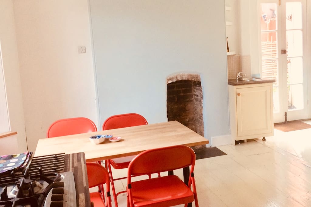 Kitchen with gas hob and electric fan oven, fridge with small freezer section and two sinks.