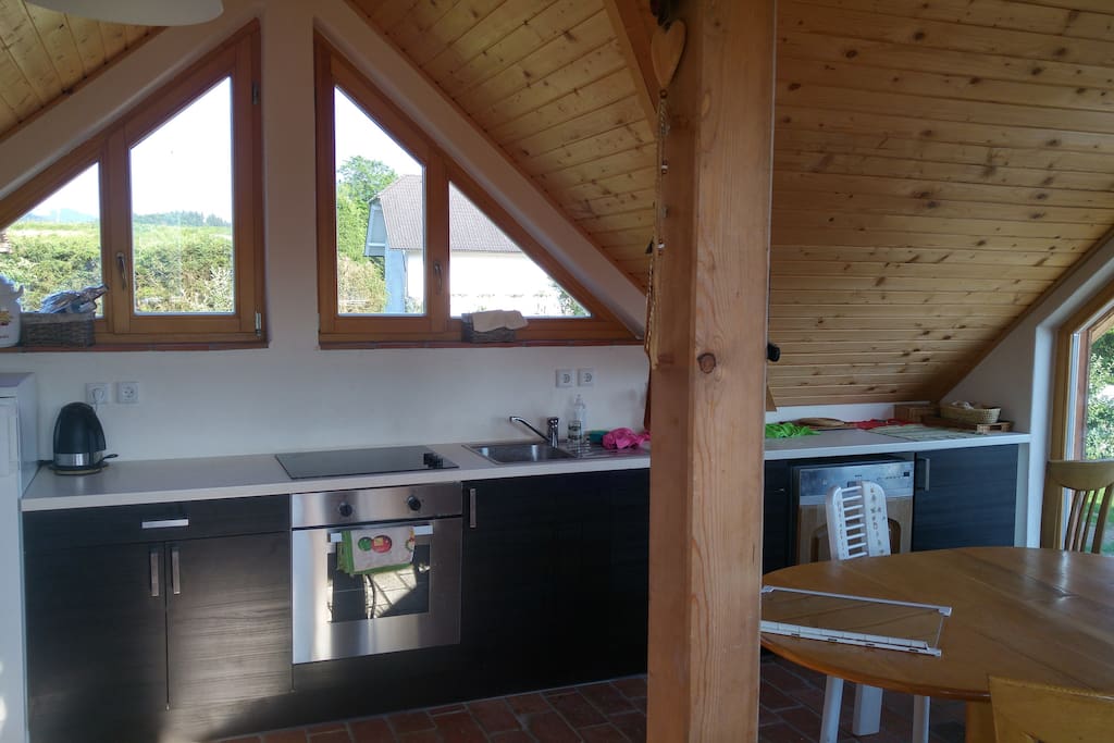 Kitchen with a big fridge with freezer, oven, dishwasher, sink, silverware and dishes