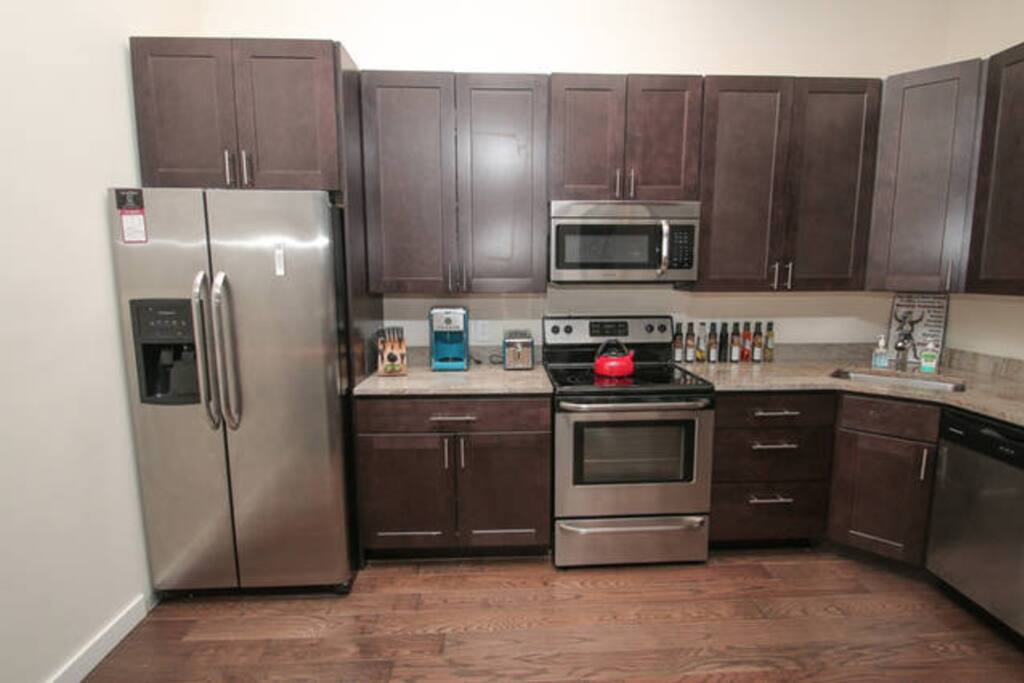 Modern complete kitchen with stainless steel appliance and granite counters