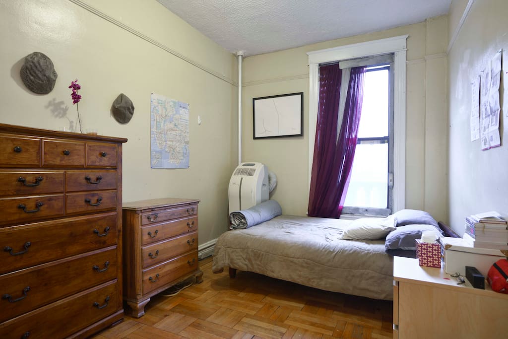 Private, well-lit bedroom. Fire escape in room, with air conditioner and large closet.