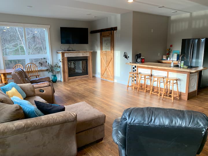 Sebule ya ghorofa ya kati yenye dineti. Hakuna jiko lakini limejaa mashine ya kutengeneza kahawa, sinki na friji. Viti 4 vya eneo la baa kwa starehe.
 Makochi 2 na kitanda ili kufurahia televisheni. Mlango wa kuteleza ni mlango wa kuingia kwenye mashine ya kuosha/kukausha ya Ghorofa ya Kati na chumba cha kulala #4.