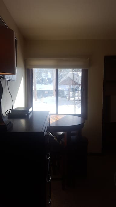 Eating area looking out window to poo/outdoor grill picnic area