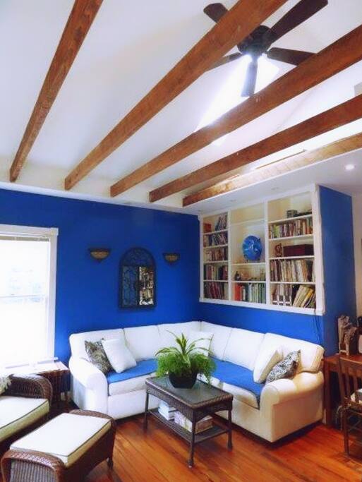Bright blue walls, sunlight, and natural beams give this apartment a Greek island vibe.