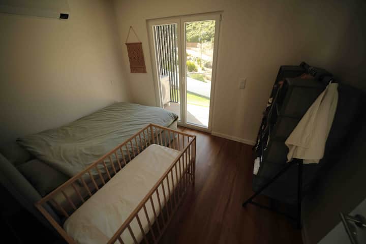 El tercer dormitorio está equipado con una cama doble (140x200cm) y una cama de bebé (60x120cm). Tiene una barandilla y acceso al balcón orientado al sur. Este balcón también se puede ingresar desde el segundo dormitorio y da al jardín.