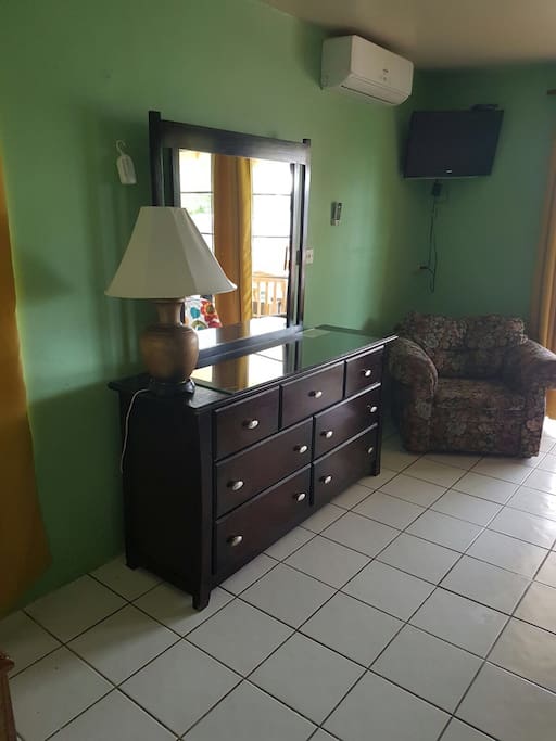 With flatscreen TV and Chester drawers with single seater sofa