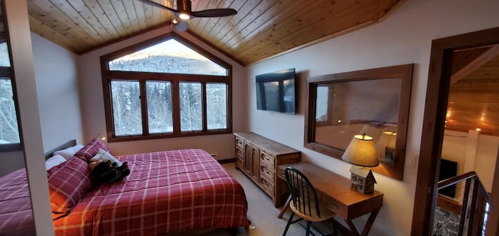 Спална соба на горниот кат со брачен кревет, биро и поглед на планината Бивер Крик