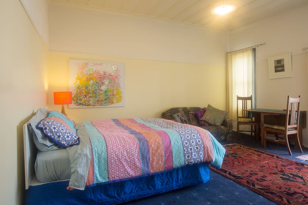 Room with queen bed, couch, dining table and chairs